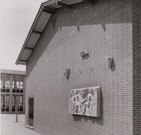 Sculptuur aan de muur van de Burgemeester Fockschoolschool wie, wat, wanneer, waar Foto: deel van een foto uit de collectie van de Beeldbank van het Stadsarchief van de gemeente Amsterdam 